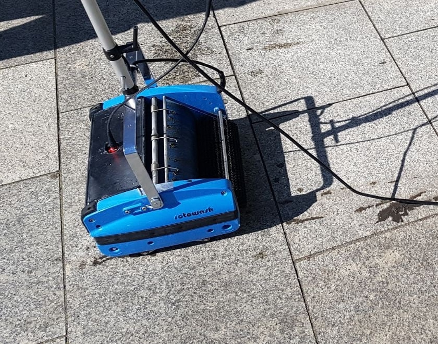 Szorowarka walcowa Rotowash podczas czyszczenia kamiennej posadzki w słońcu